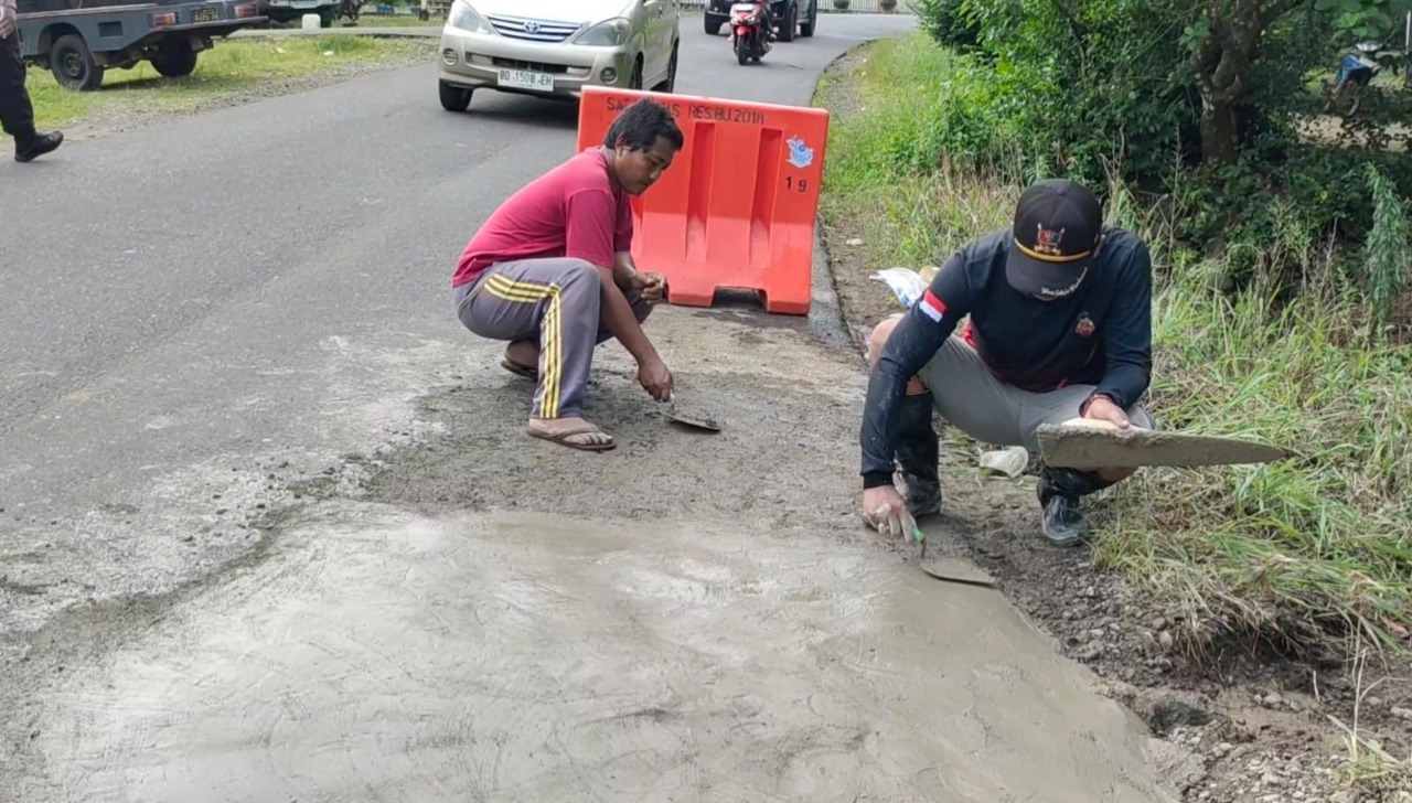 Gelar Baksos, Polsek Padang Jaya Lakukan Penambalan Lubang Jalan Raya Provinsi