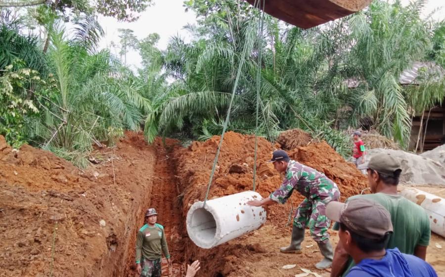 satgas TNI polri beserta warga bergotong royong memasang gorong gorong